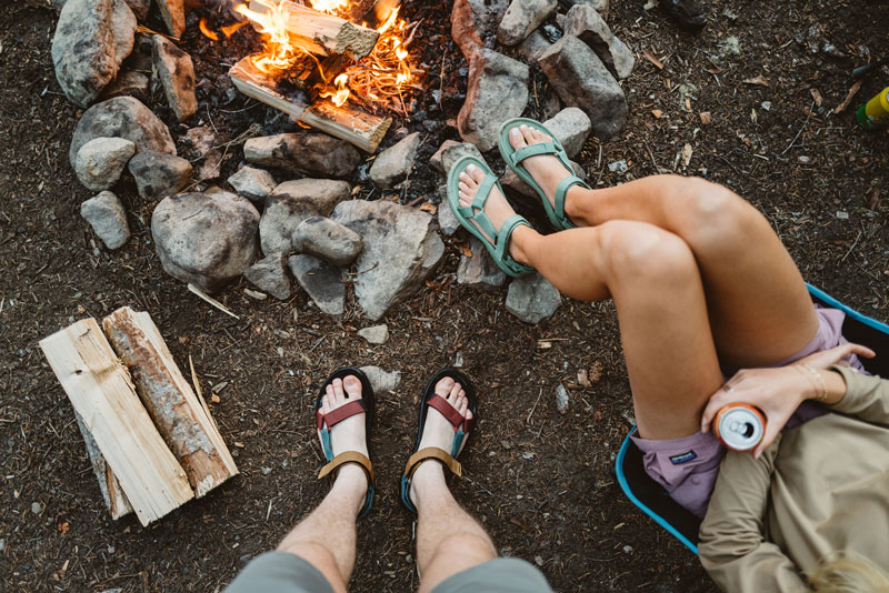 Whitney and Ben sit around a fire wearing Hurricane XLT2 sandals.