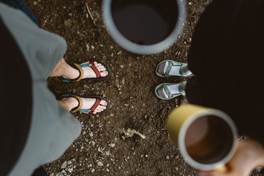 Ben and Whitney look down at their coffee mugs and feet wearing Hurricane XLT2 sandals. 